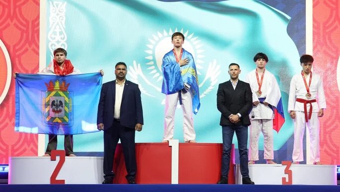 Казахстанский чемпион на пьедестале с национальным флагом